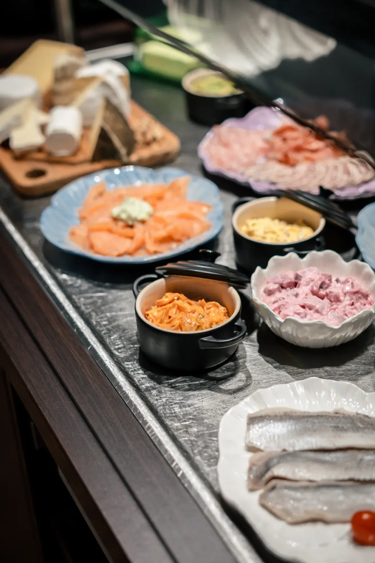 Herzhaftes Fr&uuml;hst&uuml;cksbuffet: roher Fisch, Aufschnitt und Gem&uuml;se.